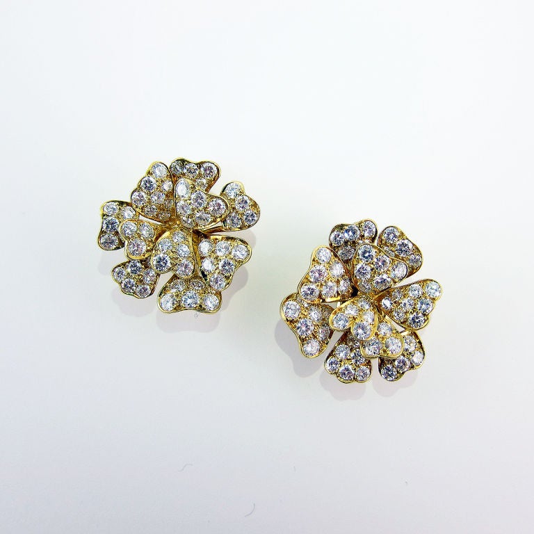 Made of 18K yellow gold and set with circular-cut diamonds in the form of a flower.  These earrings are fitted with a comfortable clip on back and sit beautifully on the ear.  They are approximately the size of a US nickel.  <br />
<br />
Signed