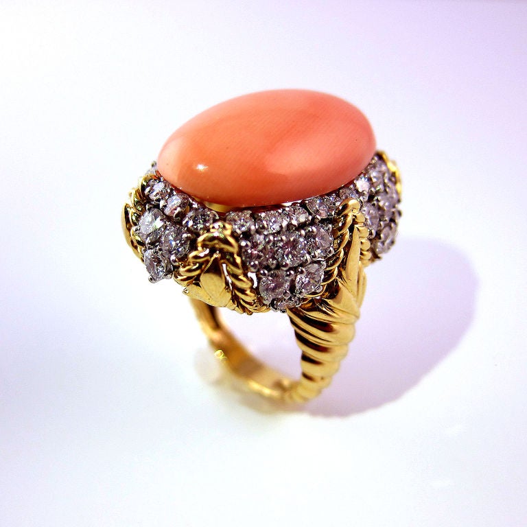 Centered with a salmon colored cabochon-cut coral and surrounded with circular-cut diamonds set in 18K yellow gold in a twisted rope motif.  Size 7*<br />
<br />
*can be sized<br />
<br />
Signed VCA and numbered