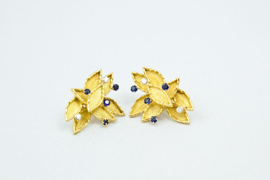 Great contemporary ear clips consisting of marquise shaped gold plaques with raised borders and ridged matt finishes set with a splattering of sapphires and diamonds. 17.2 grams, French hallmarks, serial No., signed.