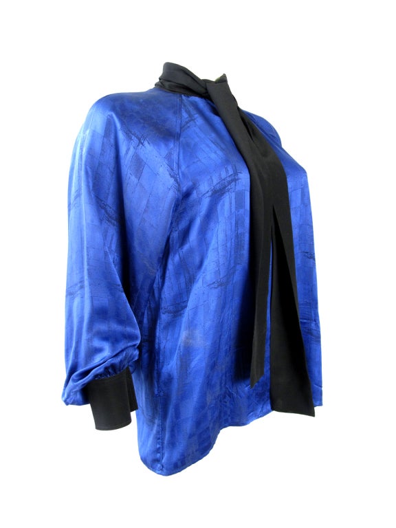 Yves Saint Laurent blue silk blouse with black tie.
40