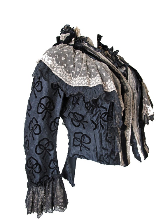 1800's French jacket with bow pattern, lace details, velvet bows. Buttons down front.  40