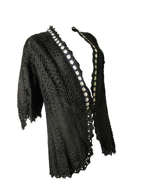 Bonwit Teller jacket circa 1900. Black woven patterned with bell sleeves. Hook and eye closures. 

Condition:  good,   flaws to lace.  40
