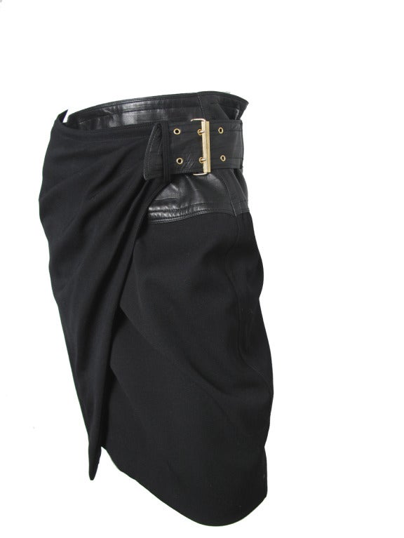Gianni Versace black wool and leather skirt with large buckle.  
28