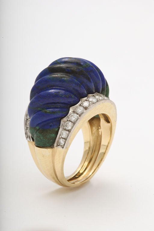 Always the innovator, David Webb was one of the first jewelers to utilize this unique stone.  The expertly carved azurite is set between two lines of diamonds, creating a bright and bold look.  Truly Webb!

From a family of jewelers dating back to