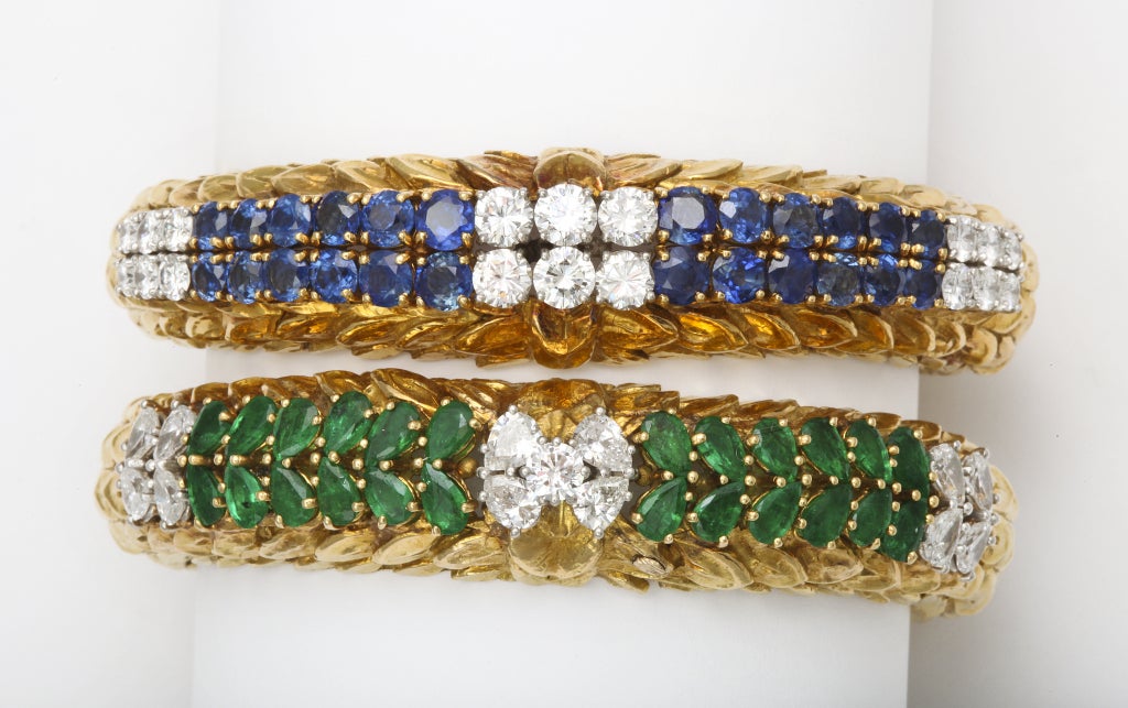 A rare, and very chic, pair of textured 18kt yellow gold, sapphire, emerald and diamond bracelets.  The flexible mountings make them comfortable to wear, while the large stones give a bold look.  They will comfortably fit up to a 7 inch