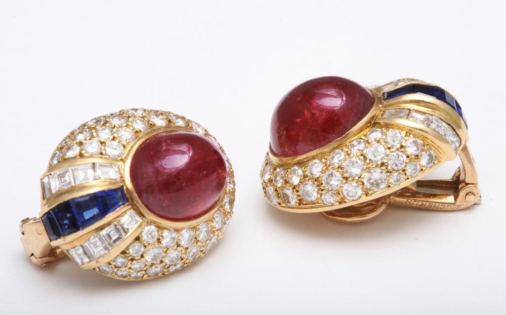 Featuring bright red cabochon rubies, these elegant earclips are further set with round and baguette diamonds as well as baguette sapphires.  The baguette stones have all been expertly cut to fit perfectly into the mounting.

For three generations