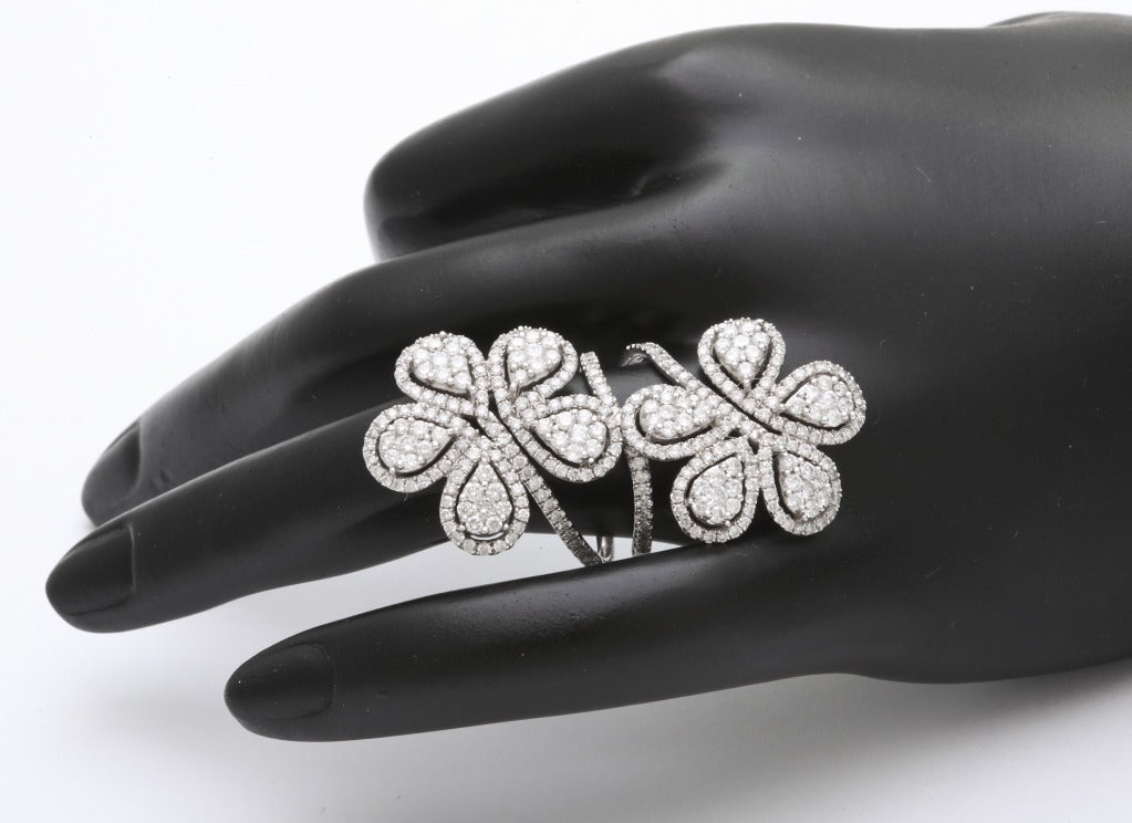 Spectacular diamond double flower ring completely set with round diamonds (331=3.23cts).  The ring measures a dramatic 1 3/4 inches in length and each flower is 7/8 of an inch wide.  Currently size 7 and sizable to fit.

From a family of jewelers
