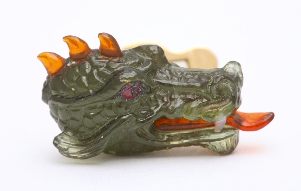 No detail has been spared in the creation of these fantastic cufflinks.  The dragon's head is expertly carved from a fine piece of Brazilian green tourmaline.  Utilizing the ancient inlaying technique of intarsia, ruby, fire opal and white agate are
