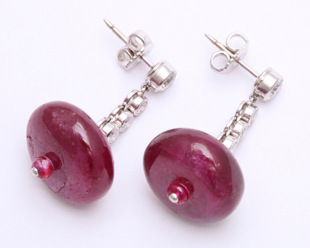 A beautiful pair of 15.5mm ruby beads (total weight 35 carats) are delicately suspended from a line of bezel set diamonds (total weight 0.70 carats).  Absolutely unique and extraordinarily finely made down to the finest detail.  

From a family of