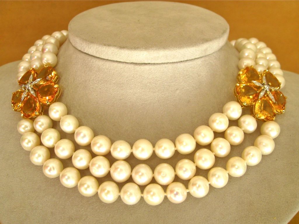 A wonderfully elegant and versatile necklace comprised of 3 strands of 9mm white, lustrous pearls accented by two vibrant citrine and diamond flowers.

From a family of jewelers dating back to 1927, Michael Kanners is renowned as both a creator