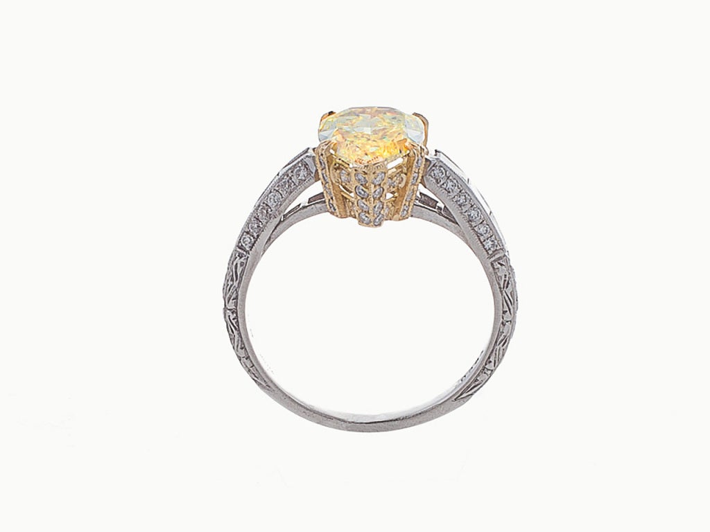 This beautiful ring centers 1 Pear Brilliant Fancy Intense Yellow diamond, 1.92 carats, clarity: SI1, even distribution of color, very good polish and good symmetry with GIA CERTIFICATE, in an 18 karat yellow gold gallery set with small round