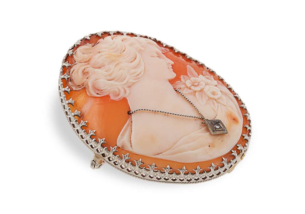 Beautiful shell cameo designed as a woman with a diamond necklace and surrounded by 18 karat white gold.