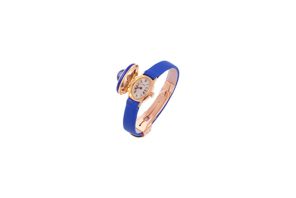 Exquisite Cartier wristwatch. The watch centers a cabochon sapphire, 4.80 carats, surrounded by platinum-set diamonds, .50 carats, and blue enamel. The off-white dial has Roman numerals, the dial signed Cartier, the movement is signed Vacheron