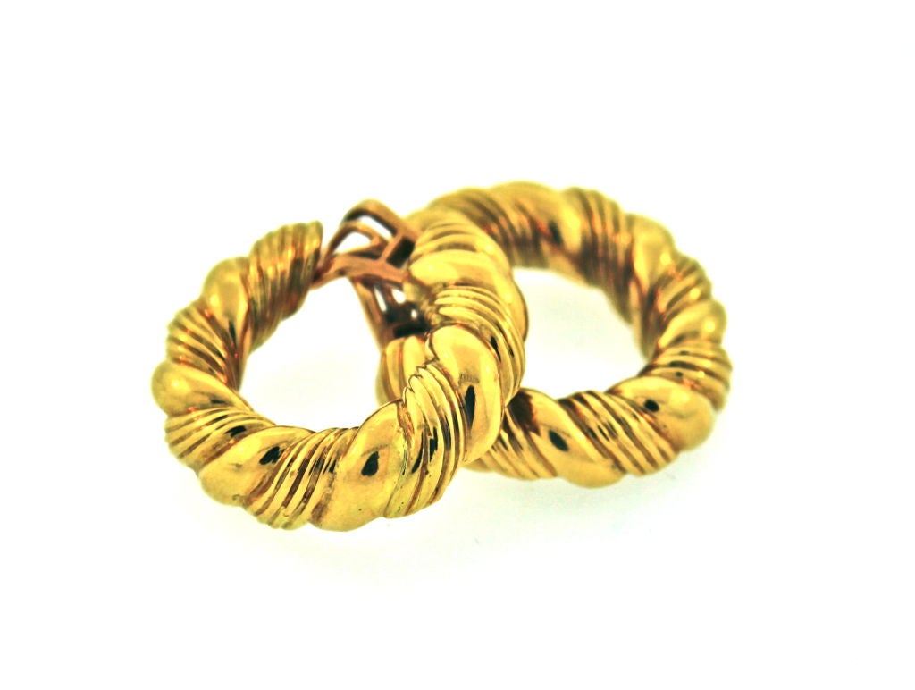 A pair of shrimp, hoop earrings in 18K yellow gold.