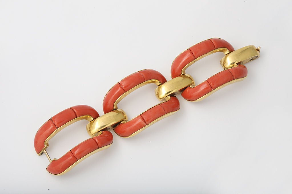 A bold link bracelet of oversized rectangular links set with coral, in 18 karat yellow gold.