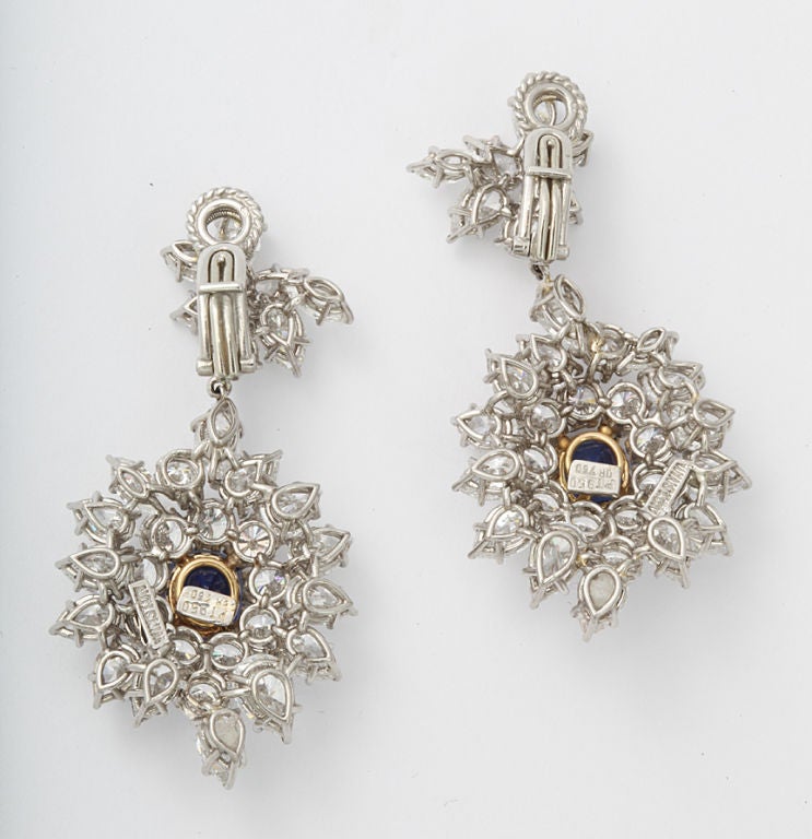 A pair of fine drop earrings set with marquise and round diamonds, with sapphires at the center of each drop in platinum and 18 karat gold.