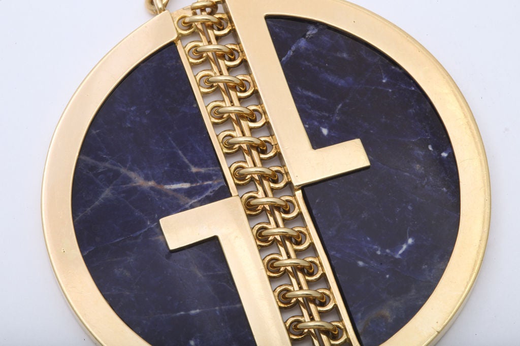 An 18 karat yellow gold pendant designed as the Gucci Logo set with Lapis Lazuli.