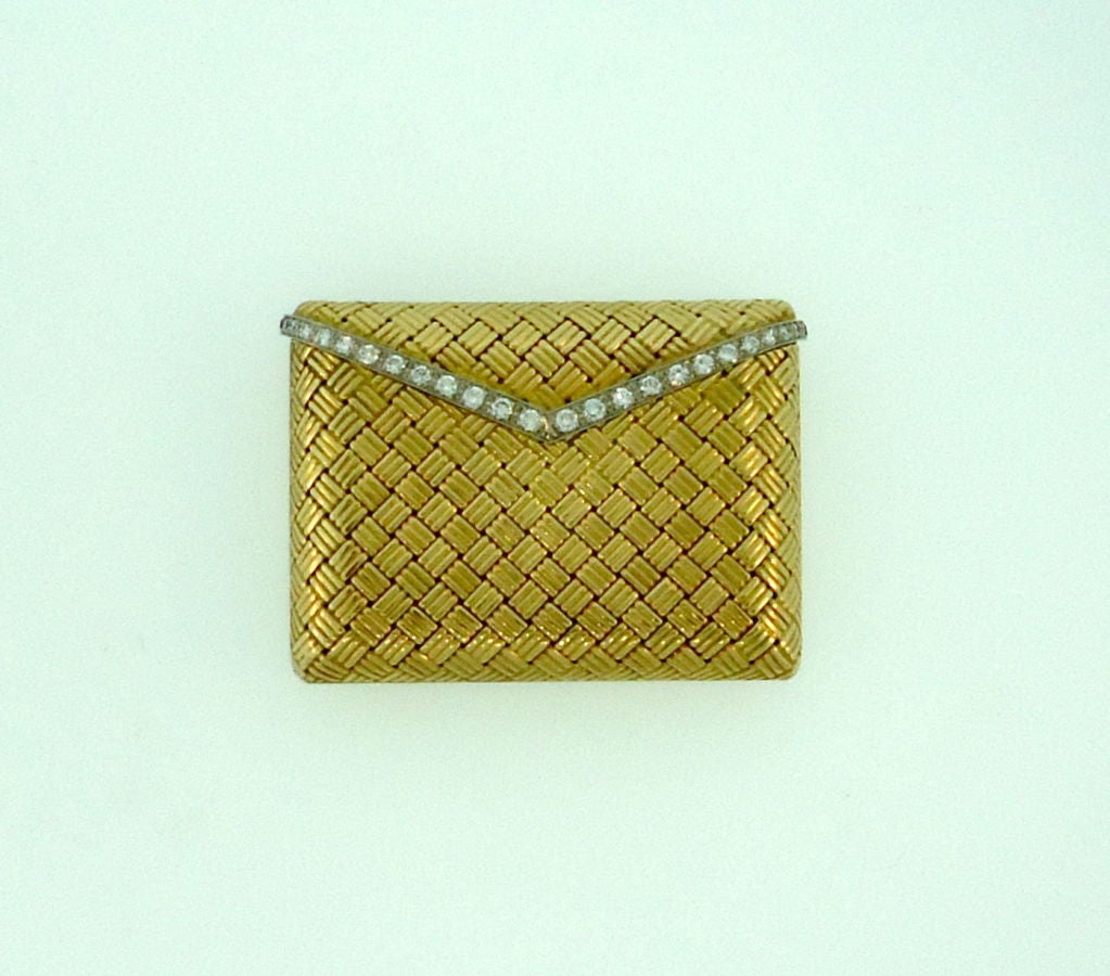 A delightful miniature ladies bedside travel clock in an 18 K yellow gold woven pocket with a row of diamond accents.