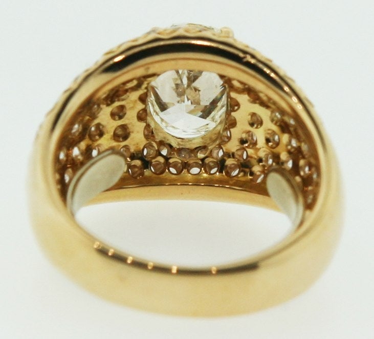 An expertly crafted 18 karat rose gold dome ring set with round diamonds and a 2 carat oval dimond at the center. Size : 5.5