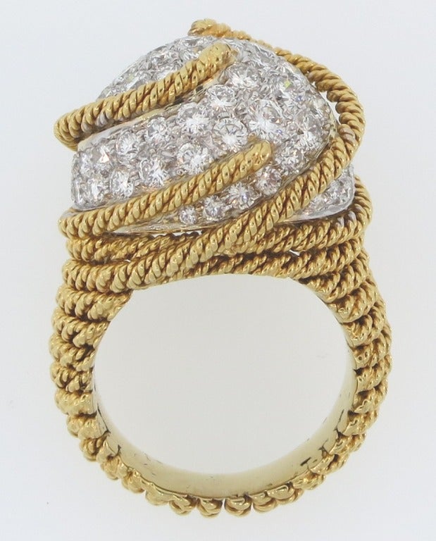 An 18 karat yellow gold rope work dome ring set with round diamonds in platinum.