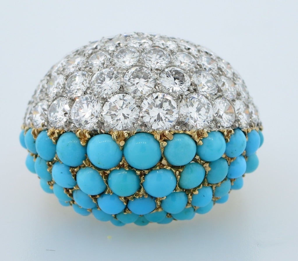 A scintilating 18 karat yellow gold dome ring set with round diamonds and persian turquoise beads .