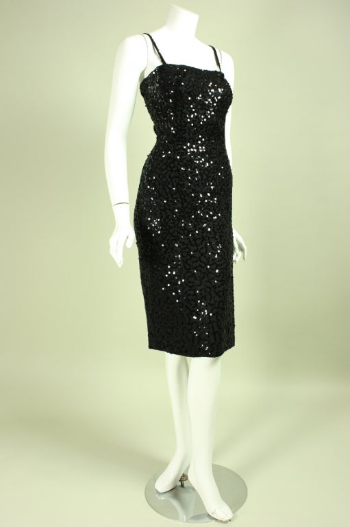 Vintage dress from Ceil Chapman dates to the 1950's through the early 1960's.  It is made of black crepe with allover sequined embellishment that is denser in the bodice than in the skirt.  Fitted throughout.  Squared neckline with narrow straps. 