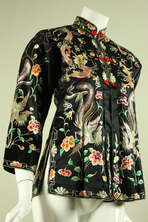 Vintage embroidered jacket originates from China and dates to the 1930's through 1940's.  It is made of black satin with allover embroidery.  It has center front frog closures, 3/4-length sleeves, and a back vent.  Fully