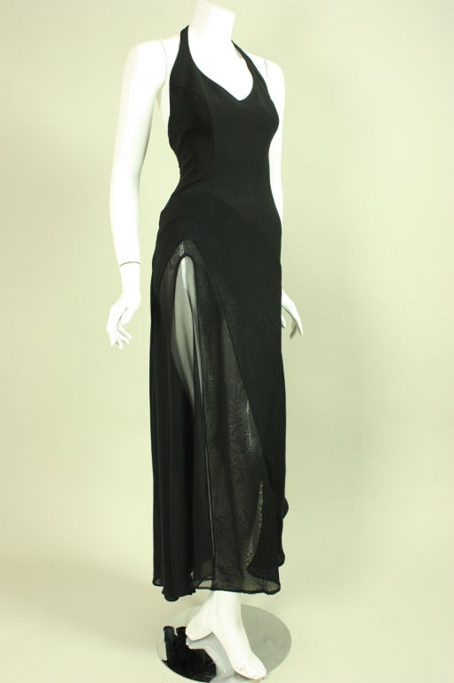 Body-hugging gown from Thierry Mugler dates to the 1990's.  It features a halter-style v-neck with a transparent chiffon insert along the right leg that gives the same effect as a thigh-high slit with slightly more modesty.  Shape of insert is