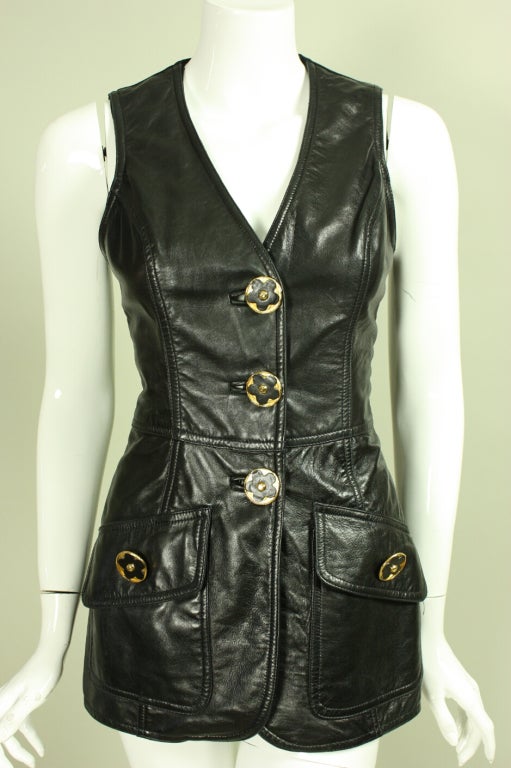 Buttery-soft leather vest from Gemma Kahng dates to the 1990's.  It has a v-neck and three center front button closures.  Knit back has adjustable waist buckle.  Flap pockets.  Lined.

Labeled size 8, but please refer to measurements as sizes have