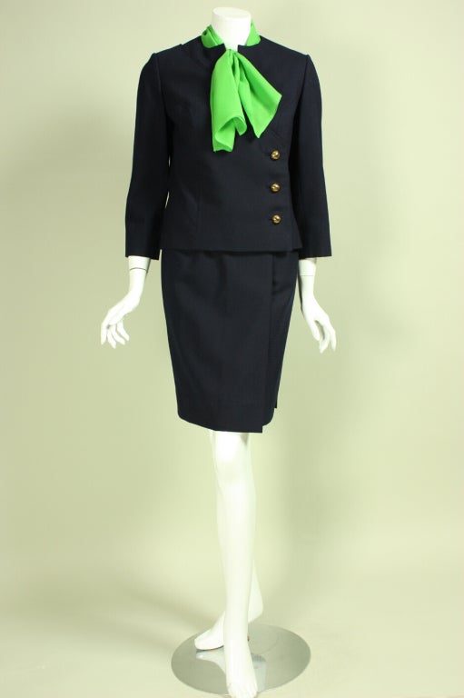 Vintage suit from Irene retailed at Bullocks and dates to the 1960's.  It is made of navy blue gabardine with a small checkered pattern.  Boxy jacket has diagonal seamed detailing, bronze-toned metal buttons, and 3/4-length sleeves.  Straight skirt