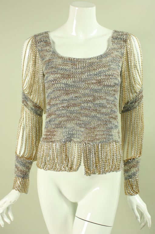 Iconic sweater from Loris Azzaro dates to the 1970's.  It features his signature chain detailing in tones of gold and silver at the sleeves, cuffs, and hem.  Scoop neck.  No closures.  Unlined.  Please note that this is an unlabeled item and is