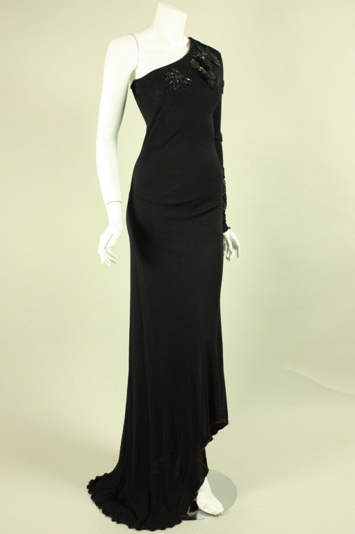 Clingy gown from iconic American designer Stephen Burrows dates to the 1970's.  It is made of black matte jersey with beaded appliques placed around the neckline and down the sleeve.  Asymmetrical hem.  Unlined.  No closures.

Please note that the