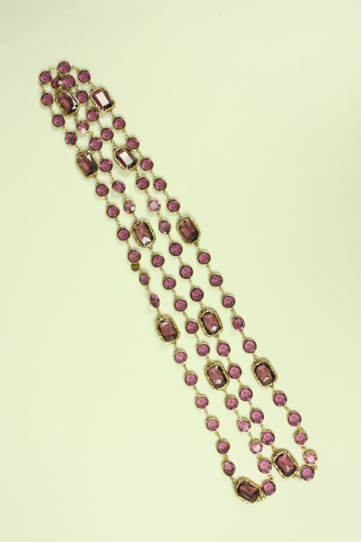 Gorgeous sautoir necklace from Chanel dates to 1981.  It is made of amethyst-colored, faceted glass that is encased with gold-toned metal.  No closures.

Length: 62