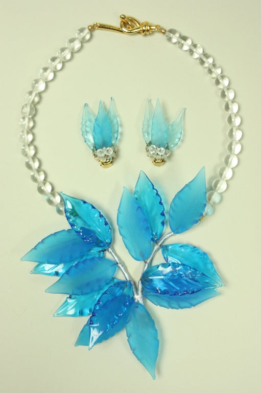 Dainty necklace and earring set dates to the late 20th Century and is made of blue and clear Italian blown glass.  Necklace centerpiece consists of transparent leaves that are attached by wire that is wrapped in silk or rayon yarn.  Earrings consist