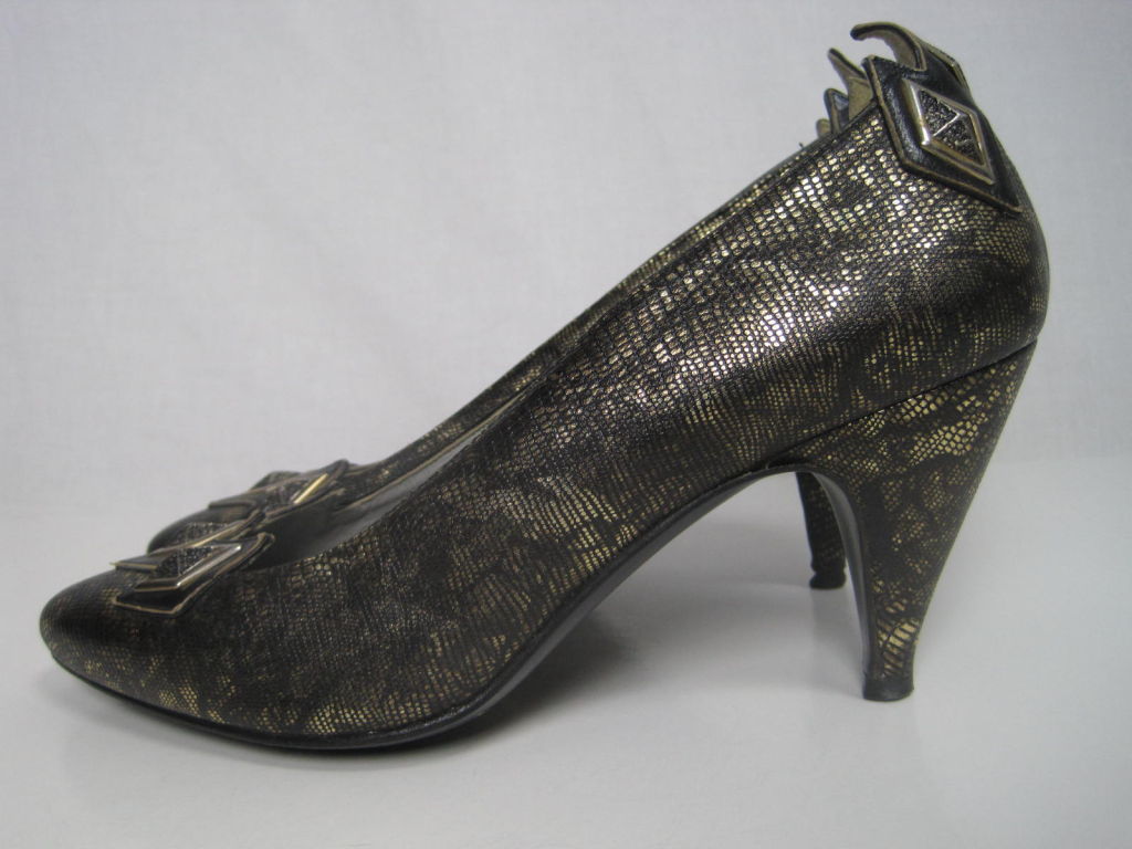 Faux snakeskin with a marbled black and gold finish.  Trio of pyramid studs on toe and at heel.  Black leather detailing.  2