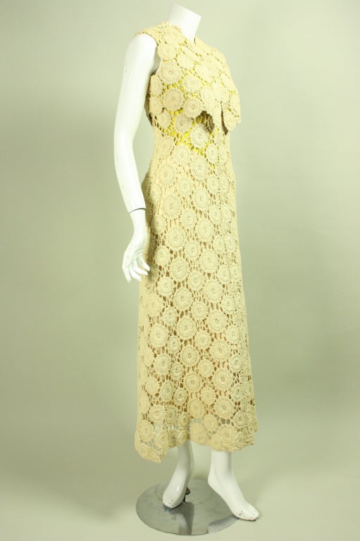 Vintage gown from Pauline Trigere dates to the 1970's and is made of cream-colored crocheted fabric.  Dress has fitted bodice with v-neck front and scoop back neck, spaghetti straps, and an a-line skirt.  Sleeveless bolero has rounded neckline and