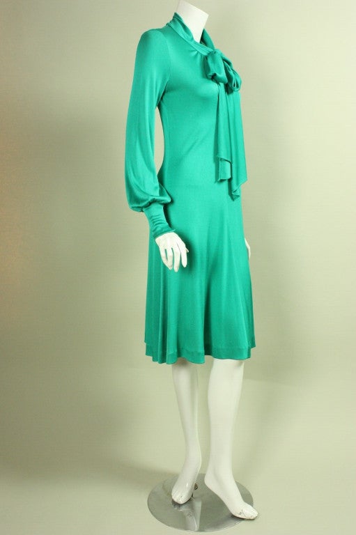 Giorgio Sant Angelo day dress dates to the 1970's and is made of emerald green matte jersey.  Deep v-neck with attached tie that can be tied at the neckline for a more demure look or lower for a sexier look.  Long sleeves with wide narrow cuffs. 