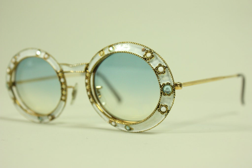 Vintage sunglasses from Christian Dior date to the 1960's.  They are made of gold-toned metal with white enamel and rhinestones on the front.  

Width: 5