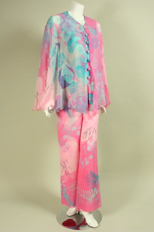 Two-piece blouse and pant ensemble from Hanae Mori dates to the 1970's.  It is made of pink and sky blue silk chiffon with a heavier silk underlayer.  Both fabrics feature the same delicate floral print.  Blouse has round neck, center front covered