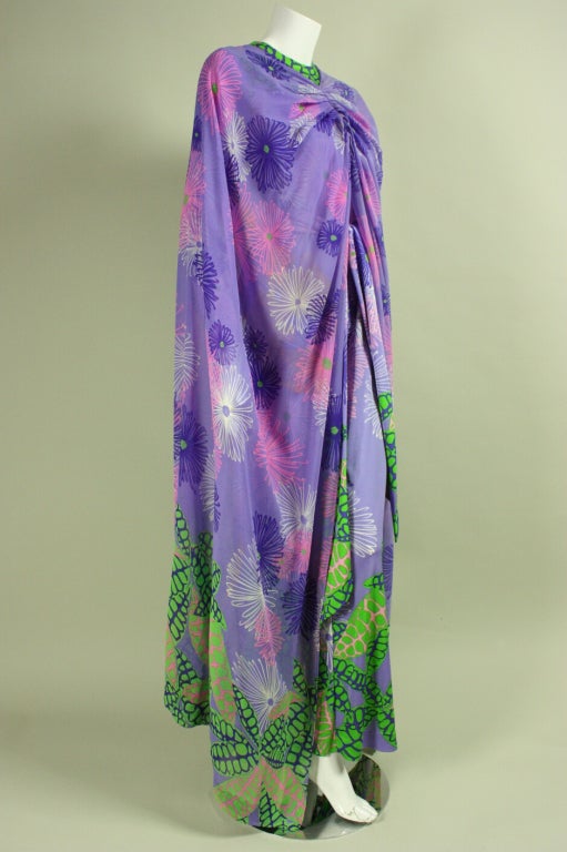 Vintage cape and jumpsuit ensemble from La Mendola dates to the 1970's and is made of printed lavender silk and jersey, respectively.  The jumpsuit features a round neck, long tapered sleeves, center back zipper, and detached belt.  The cape is
