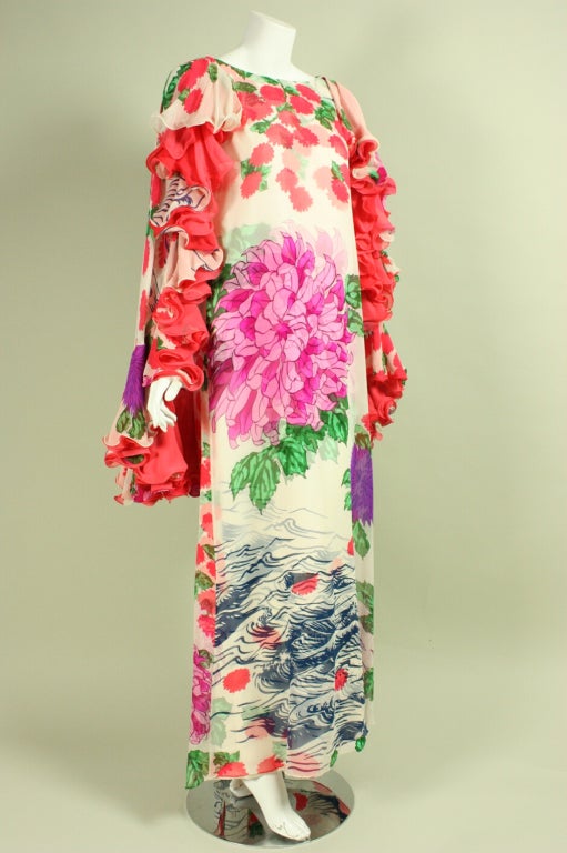 Evening gown from Hanae Mori dates to the 1970's and is made of white silk chiffon with a heavier silk under-layer.  Both fabrics feature the same multicolored floral print that overlap in such a way that makes them appear to be three-dimensional. 