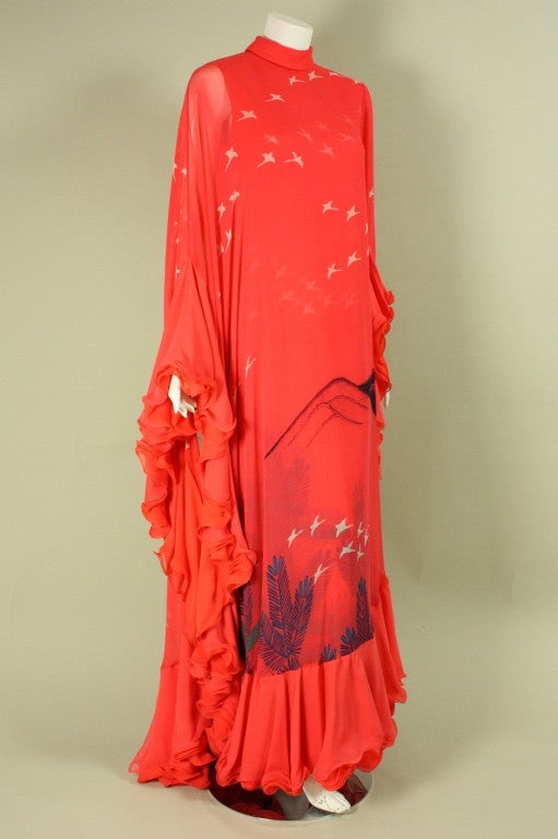 Vintage gown from Hanae Mori dates to the 1970's and is made of coral silk chiffon with a coral silk underlayer featuring the same print.  Mock neck.  Asymmetrical sleeves with one being a regular long sleeve with snap cuffs and the other being more