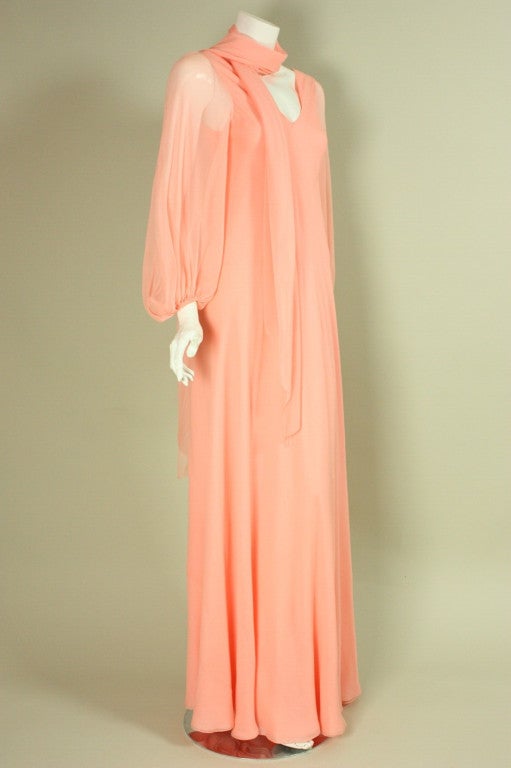 Vintage gown from Greek American designer George Stavropoulos dates to the 1970's.  It is made of layers of salmon-colored silk chiffon.  Front and back v-neck.  Long sleeves with elasticized cuffs.  A-line shape.  Center back zipper.  Lined with