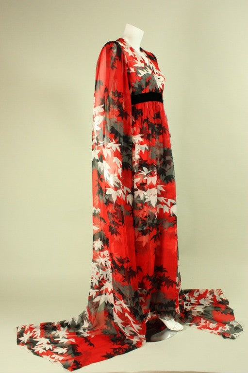 Vintage gown from Hanae Mori dates to the 1970's and is made of red chiffon with an allover leaf print in black, white, and gray.  Fitted bodice has v-neck, empire waistline, and gathering all around the waist, which creates fullness in the chiffon