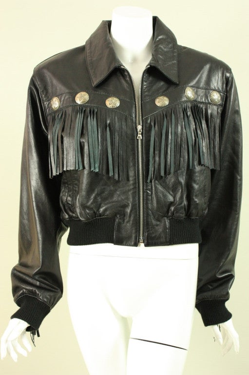Vintage jacket from Michael Hoban for North Beach Leather is made of buttery soft black leather.  It features long fringe across the front, back, and down the sleeves.  Large silver-toned discs are etched and follow the lines of the fringe.  Turn
