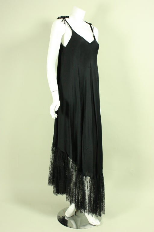 Vintage gown and shawl from Vicky Tiel are made of black silk with fine lace trim.  Slinky gown has a v-neck, double straps that are adjustable, and a v-shaped hem.  Triangular shawl has lace trim on two sides.  Dress has no