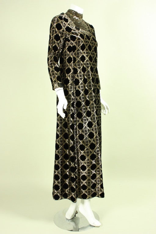 Vintage gown from James Galanos dates to the 1970's and is made of black and gold velvet.  Front bib is entirely covered with gold and black sequins.  Stand collar.  Fully lined.  Center back zipper.