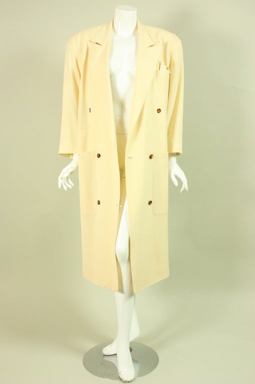 1980’s through the early 1990’s double-breasted coat by Jean-Paul Gaultier for Gibo is made of cream gabardine.  It has an inverted v-shaped silhouette with very strong shoulders that are heavily padded.   Pearl and appliqued dainty details at