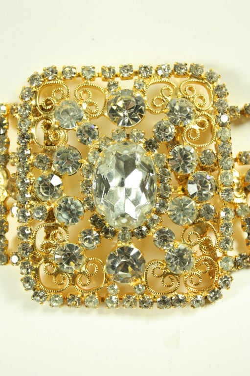 Ornate belt from Kenneth J. Lane is made of gold-toned metal that is set with faceted clear rhinestones. Scrolling filigree detail.  Hook closure.  Belt likely dates to the 1960's. 

Measurements-
Width: 1 3/4