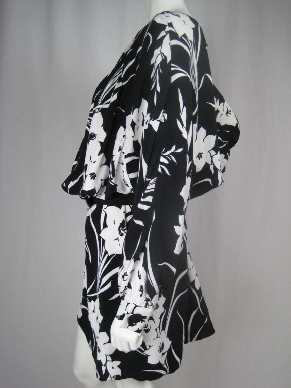 Black and white silk crepe dress/coat from Maruscha and Neiman Marcus.  Large, bold floral print.  Seams of exaggerated raglan sleeves meet just below center front neckline.  Front gathering follows these seams and extends diagonally down each side.